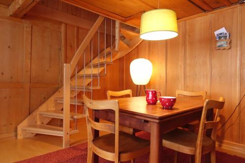 ein Esszimmer mit einem Holztisch und einer Treppe in der Unterkunft Apartment Sandgasse in Elm