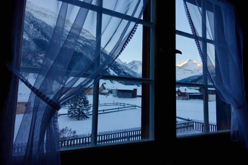 a window with a view of a snow covered mountain at Apartment Sandgasse in Elm
