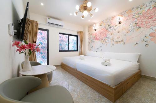 a bedroom with a bed and a vase of flowers on the wall at The Pivot Suite Ben Thanh - District 1 in Ho Chi Minh City