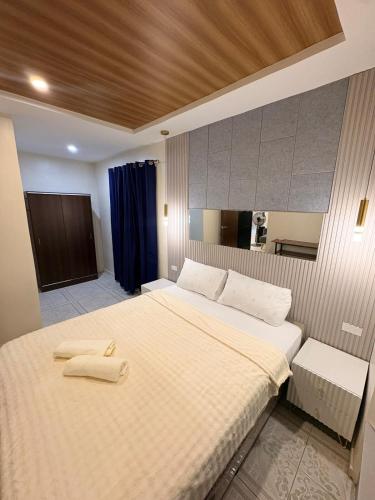 a bedroom with a large bed with two towels on it at BMF Homestay Jacuzzi Villa 2 in Sagcahan