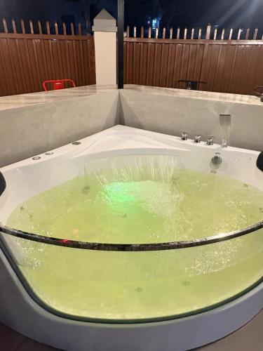 a bath tub filled with green liquid at BMF Homestay Jacuzzi Villa 2 in Sagcahan