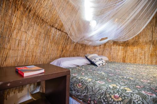 a bedroom with a bed and a table with a book at Oaxaca Caracol in Agaete