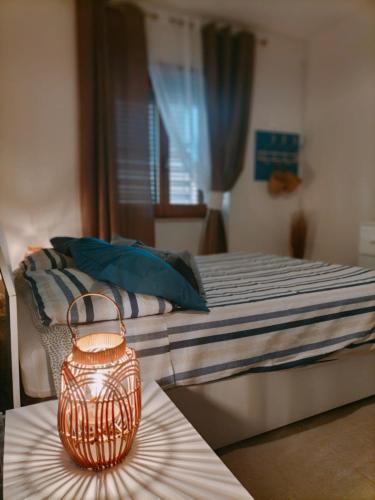 a bedroom with a bed with a candle on a table at APPARTAMENTO CORALLO with PRIVATE GARDEN in Olbia