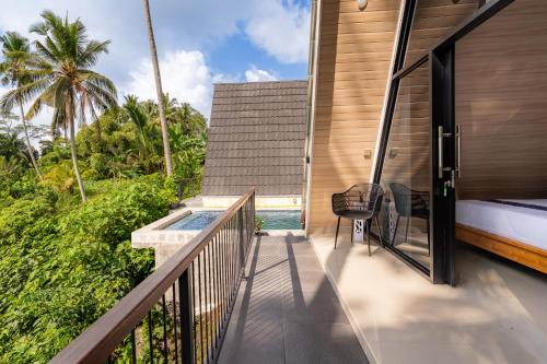 a balcony of a house with a swimming pool at Green Tara Valley Ubud by Betterplace in Ubud