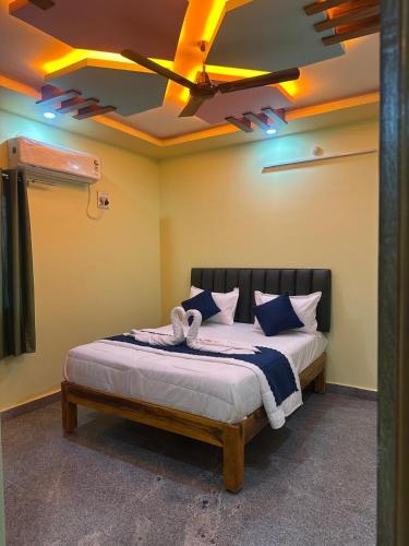 a bedroom with a bed with a ceiling with lights at wonderful stays in Tirupati