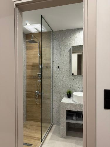 a bathroom with a shower and a sink at Luxor Suites Olimpou in Thessaloniki
