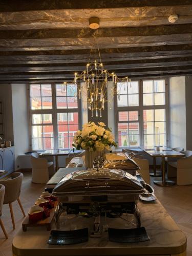 a dining room with a table and a chandelier at The Three Sisters Hotel in Tallinn