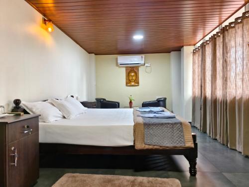 a bedroom with a bed with a wooden ceiling at Ambadi's villa -Lake view resort in Pallipuram