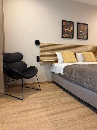 a bedroom with a bed and a chair in it at Luxor Suites Olimpou in Thessaloniki