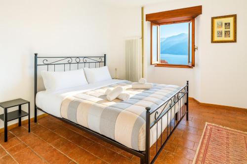 a bedroom with a large bed with a window at Panorama Lake Relax in Nesso