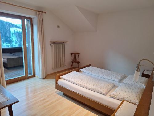 ein Schlafzimmer mit zwei Betten und einem großen Fenster in der Unterkunft Ciasa Saina in Wengen