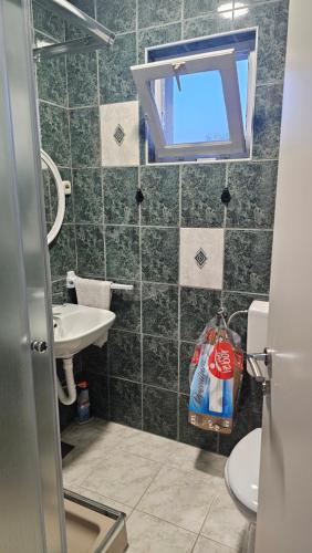 a bathroom with a sink and a toilet and a window at Apartment 42 in Ljubuški