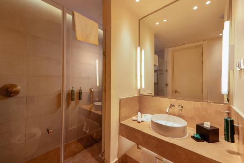 a bathroom with a sink and a shower at Doubletree By Hilton Ben Guerir Hotel & Residences in Benguerir