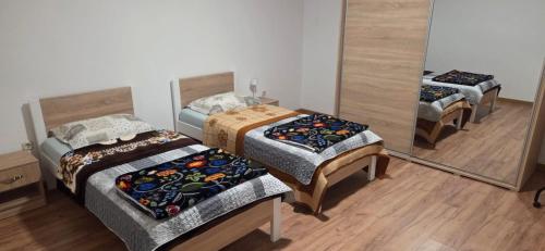 three beds in a room with a mirror at Apartment 42 in Ljubuški