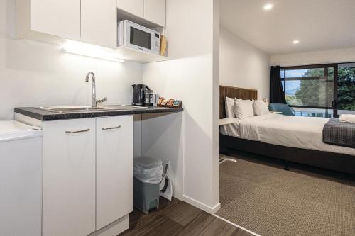 a kitchen with a sink and a bed in a room at Alpine Chalets in National Park