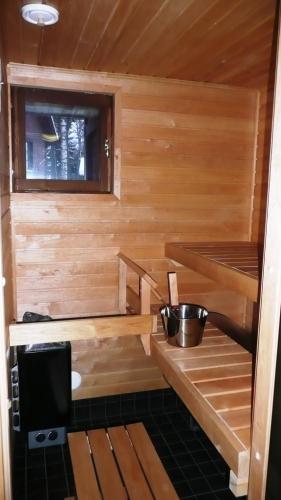 a wooden sauna with two shelves and a window at Lomaniini in Tahkovuori