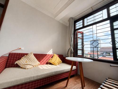 a couch in a room with a table and a window at Local Homestay in Hanoi