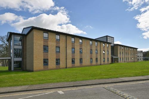 a large brick building with a grass field in front at Fire Service College in Moreton in Marsh