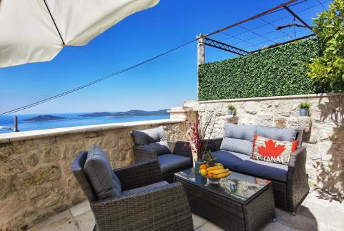 a patio with chairs and a table with a view of the ocean at Villa Dalmata in Brsečine