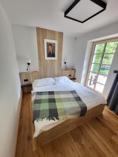 a bedroom with a bed with a plaid blanket on it at PEC 140 - apartmány Máj in Pec pod Sněžkou