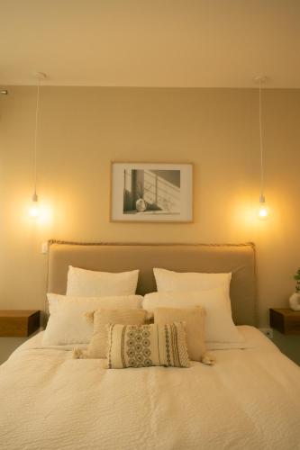 a bedroom with a white bed with white pillows at La maison du Potier in Valras-Plage