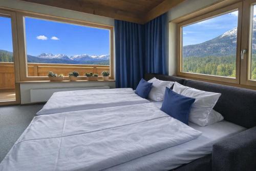 a bedroom with two beds and a large window at Chalet Cristall in Leutasch