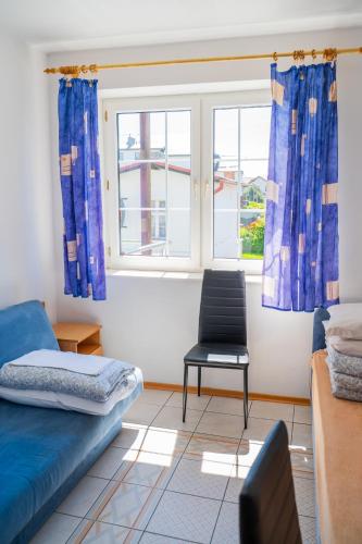 a room with a bed and a chair and a window at Helena in Karwia