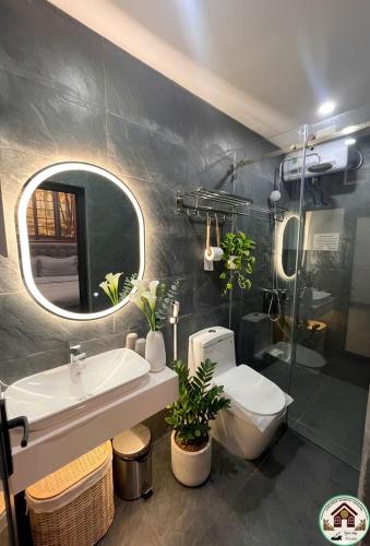 a bathroom with a sink and a toilet and a mirror at Sunflower Homestay Hai Phong in Hai Phong