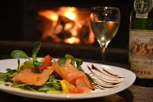 a plate of food on a table with a glass of wine at Gec II in Ivanec Bistranski