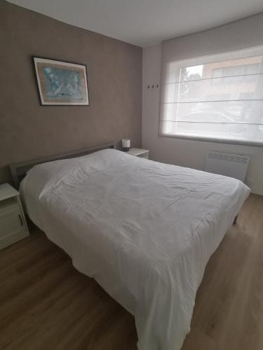 a bedroom with a white bed and a window at Marisol in Bredene