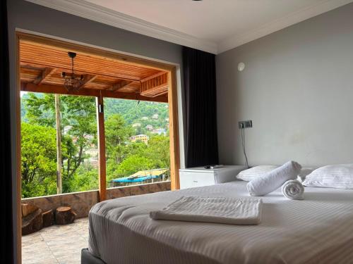 a bedroom with a large bed with a large window at Sarp Bungalov in Kemalpasa