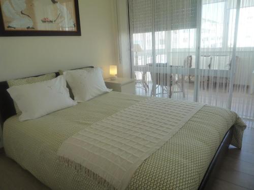 1 dormitorio con 1 cama y vistas a un balcón en Casa Mar, en Costa da Caparica