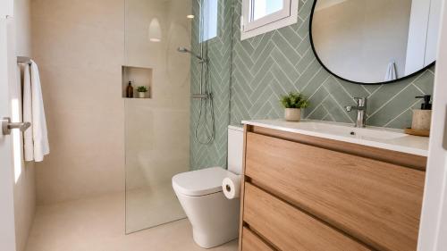 a bathroom with a toilet and a sink and a mirror at Hermosa casa con piscina cerca de la playa de Punta Prima in Punta Prima