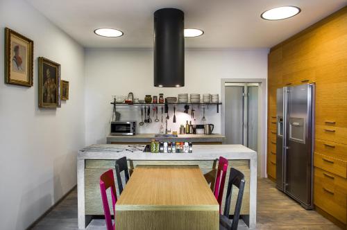 a kitchen with a wooden table and a refrigerator at Apartmány Vinařství Václav in Hustopeče