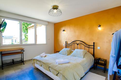 a bedroom with a bed and a desk and window at Studio Le Jardin in Lison