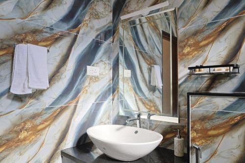 a bathroom with a sink and a marble wall at MHOMES Resort - Madurai in Alagar Kovil