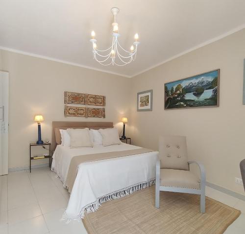 a bedroom with a bed and a chandelier and a chair at La Chicca nel Barocco - Modica Centro - Indipendente in Modica