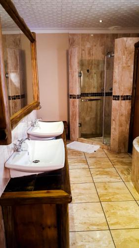 a bathroom with two sinks and a shower at Aark Guest Lodge in Vanderbijlpark