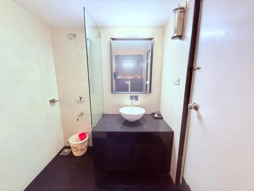 a bathroom with a sink and a mirror at Hotel Garden Panvel - Near Navi Mumbai Airport in Navi Mumbai
