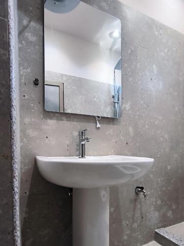 a bathroom with a white sink and a mirror at City Center Hostel in Shkodër