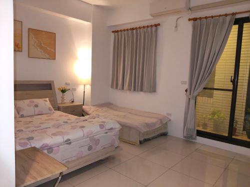 a bedroom with two beds and a window at Daiwen Homestay in Jiaoxi