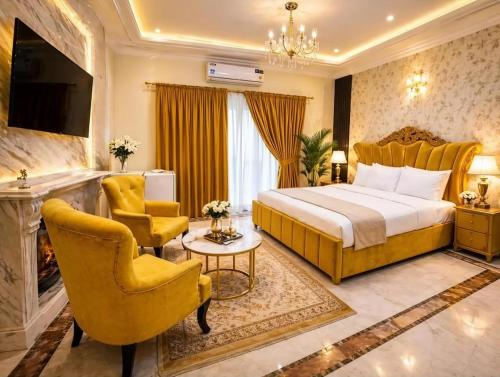 a hotel room with a bed and chairs and a fireplace at The Eastern Lodge in Islamabad