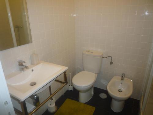 a bathroom with a white toilet and a sink at Casa Mar in Costa da Caparica