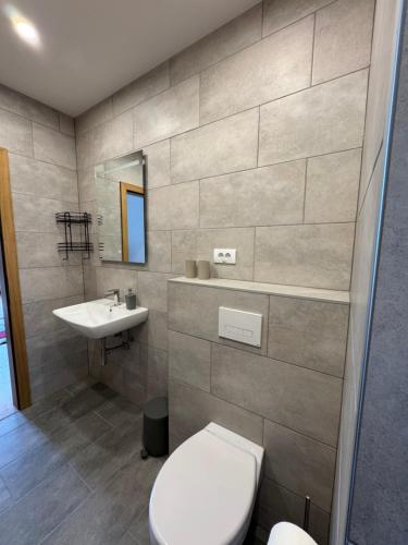 a bathroom with a toilet and a sink at Primera Apartments in Palić