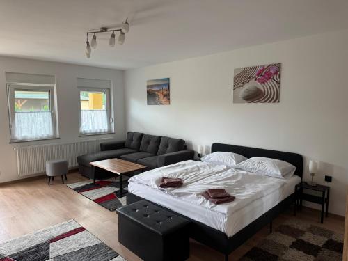 a bedroom with a bed and a couch at Primera Apartments in Palić