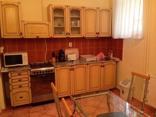a kitchen with wooden cabinets and a stove at Péterfia Apartman in Debrecen