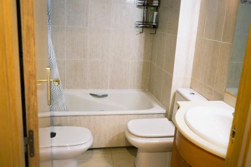 y baño con aseo, bañera y lavamanos. en Apartamento Port Marino, en Cambrils