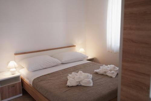 a bedroom with a bed with two white towels on it at Oaza in Nerezine