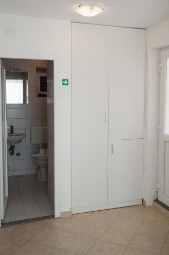 a bathroom with a toilet and a sliding door at Oaza in Nerezine