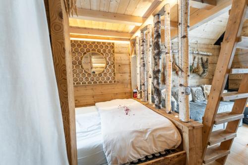 a room with a bunk bed in a tree house at Lodge 3 - LE JOLIS CHALETS in Barbey-Séroux